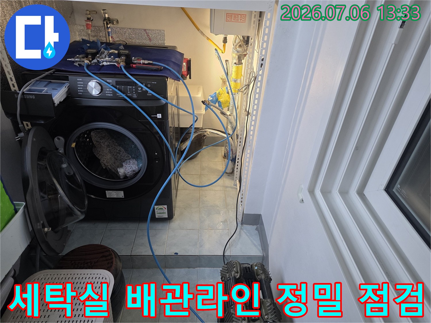 세탁 공간 내 노출된 파란색과 하얀색 배관 및 계량기부