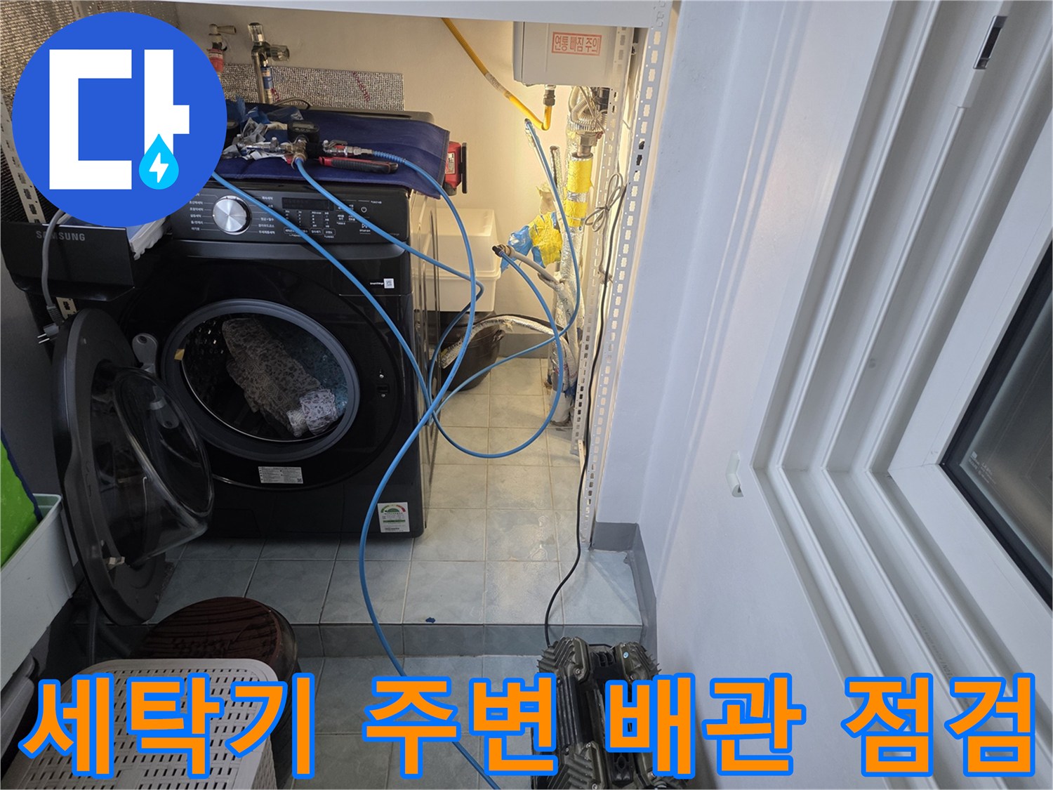 세탁기 뒤편-노출된 수도 배관과 점검 장비 모습