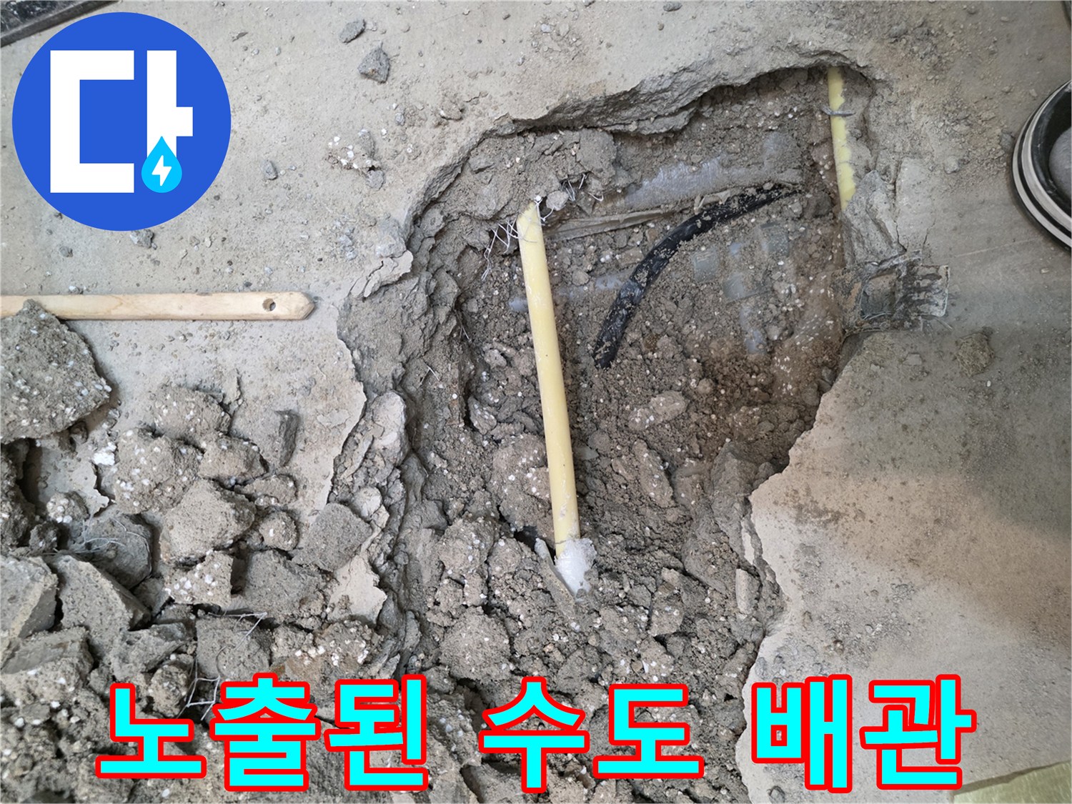 콘크리트 파편 속에 드러난 노란색 배관과 주변 흙의 상태