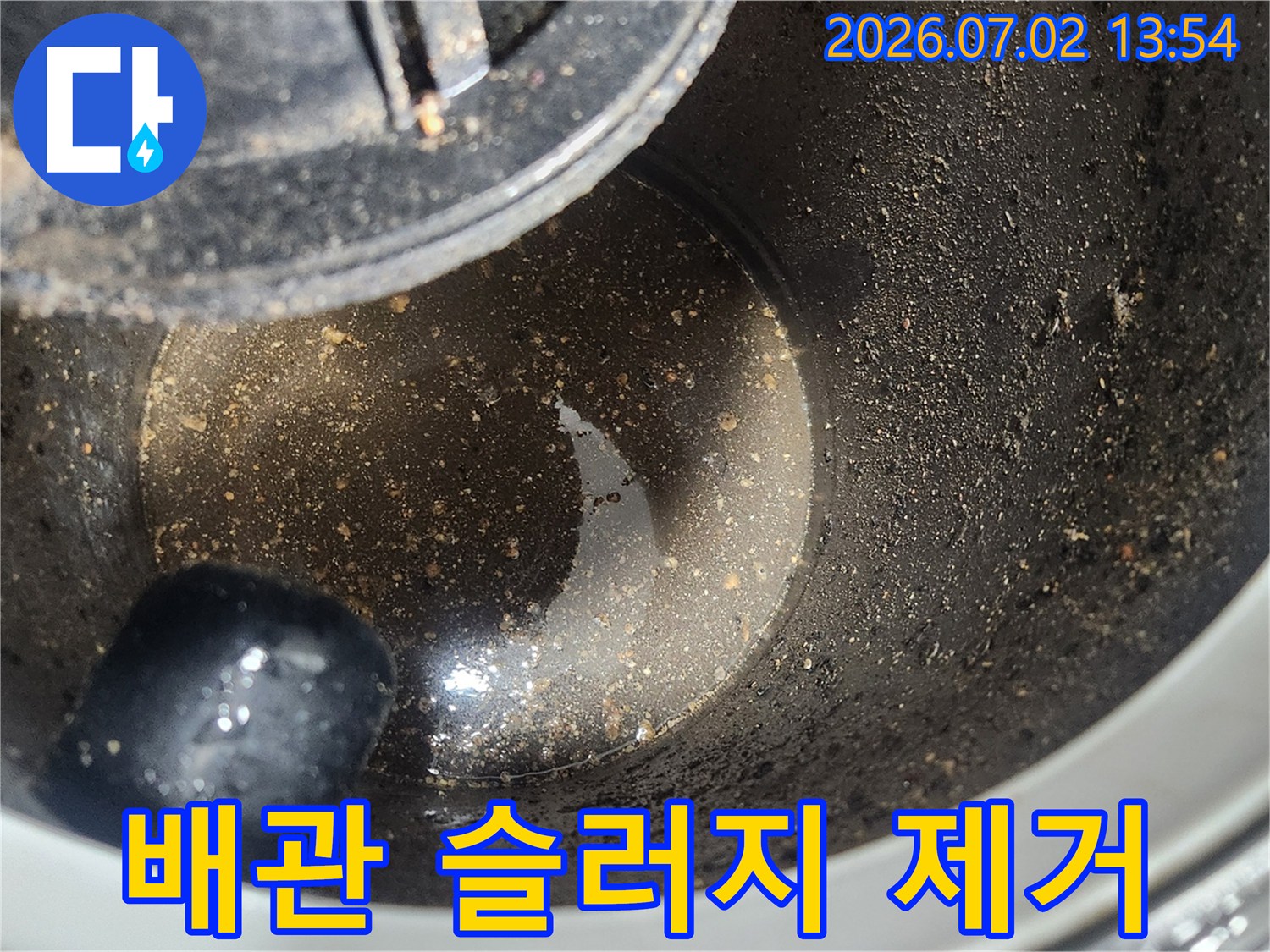 배관 스케일링 작업 후-석션 장비 내부에 흡입된-굳은 기름 슬러지 이물질을 보여주는 사진