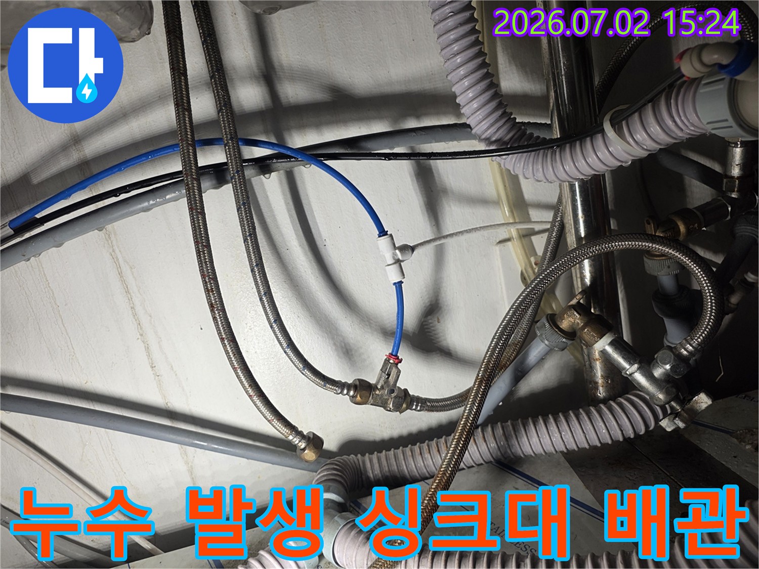 싱크대 아래쪽 노후된 고압 호스와 연결부의 파손 상태 촬영