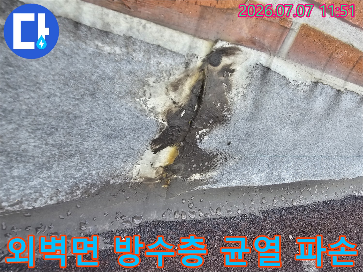 벗겨지고 갈라진 외벽 마감재와 노출된 내측 층의 모습