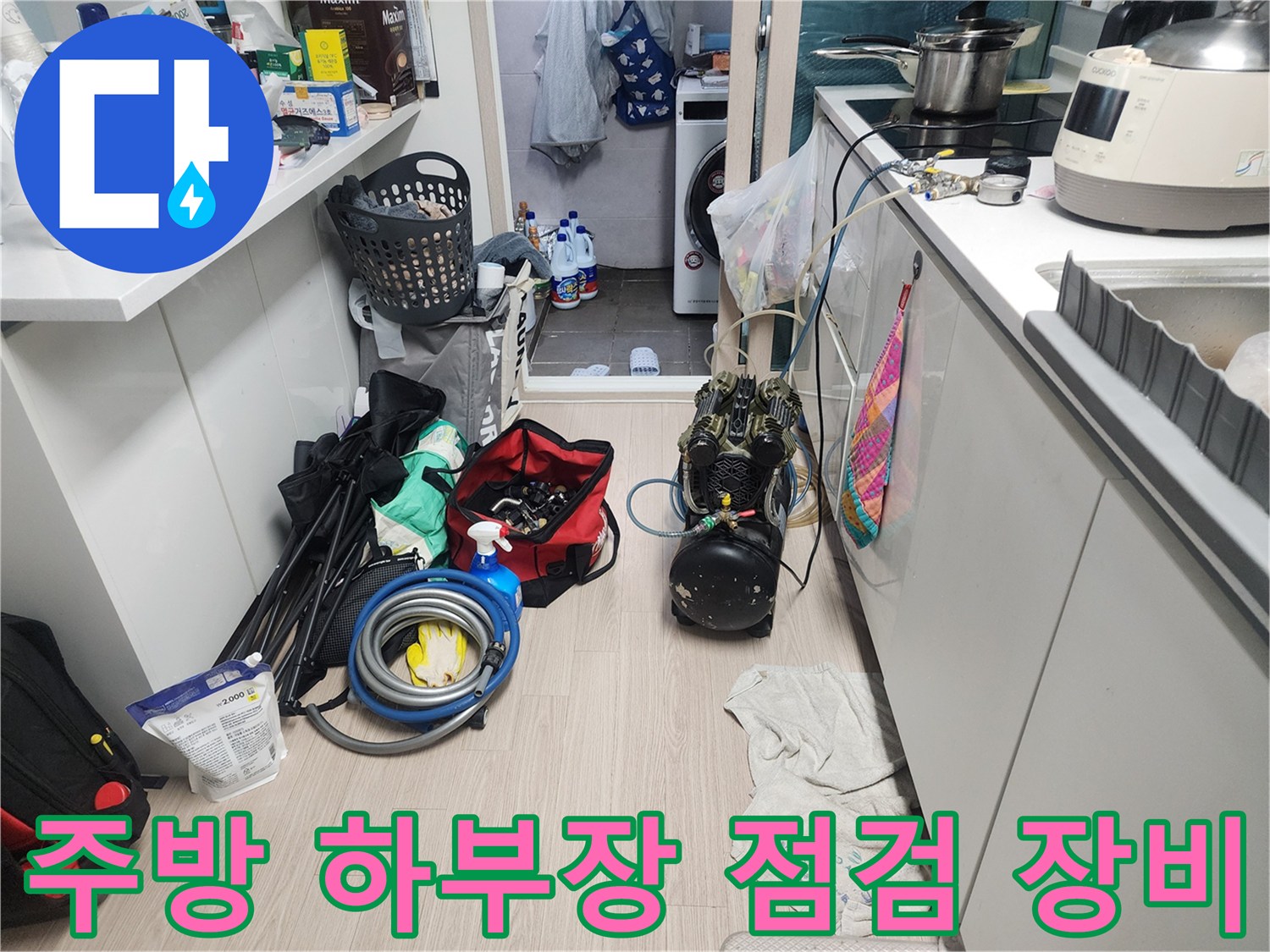 싱크대 아래 공간에 배치된 누수 탐지용 압력계와 작업 도구 세트