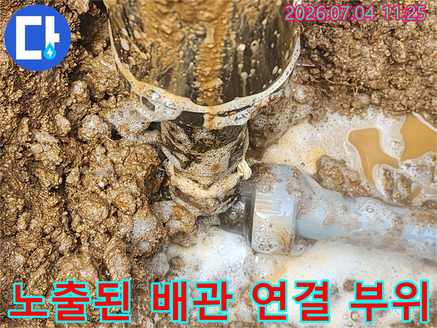 흙과 진흙이 묻은 파손된 배관 연결부 사진