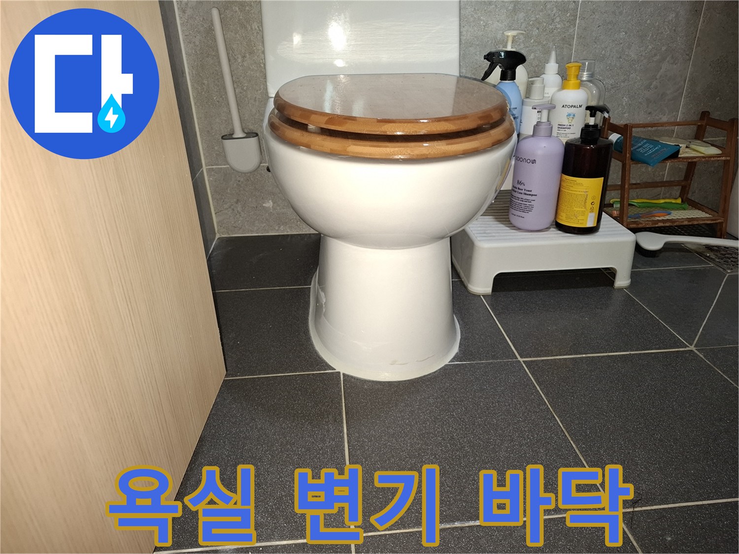 변기와 주변 세정제들이 놓인 욕실 내부 모습입니다.