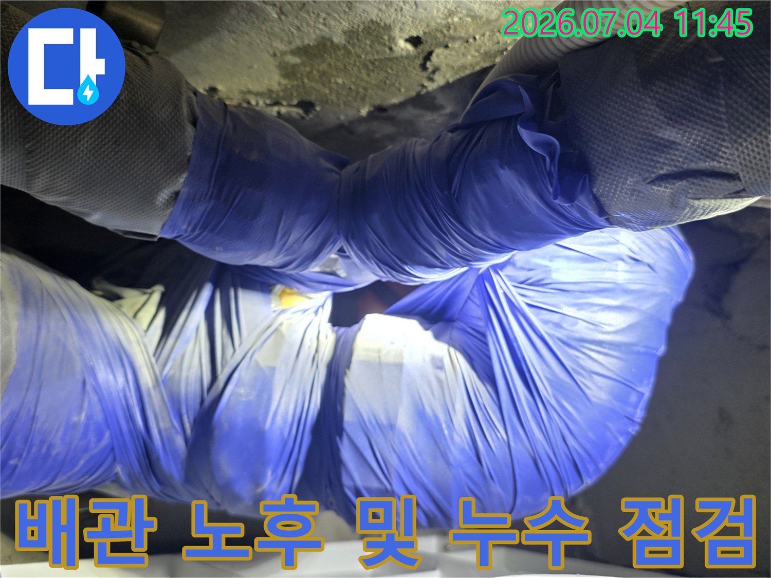 천장 내부 배관 연결 부위를 정밀하게 조사하는 현장 사진