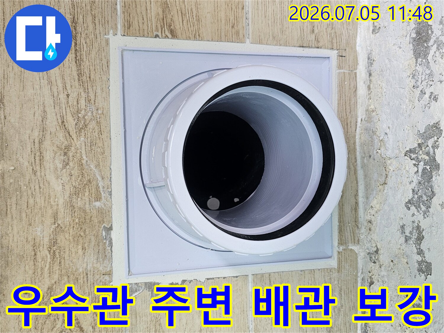 회색 마감재로 보호된 우수관 입구의 상세 모습