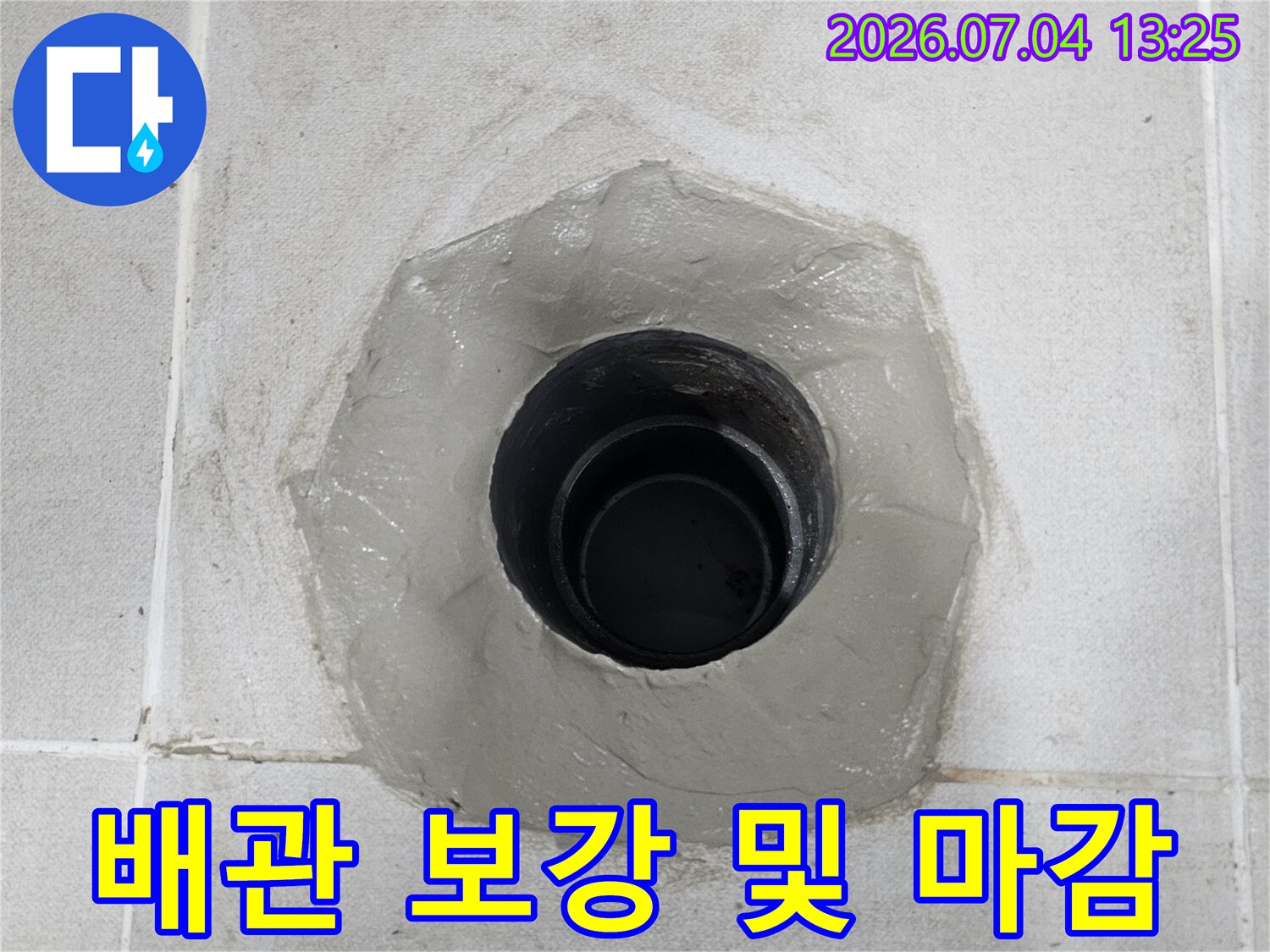 타일 파쇄 부위에 배관 연결부와 방수재가 채워진 모습