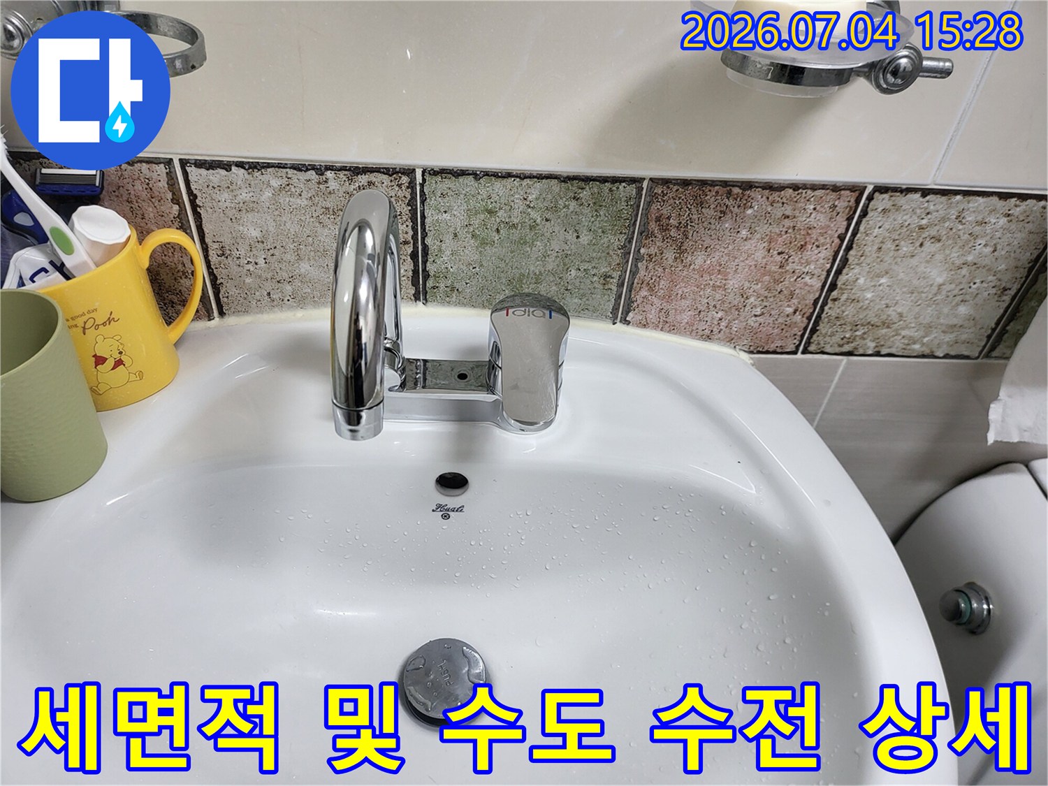 깨끗한 화장실 내부 세면대와 금속 재질의 공용 수도 수전