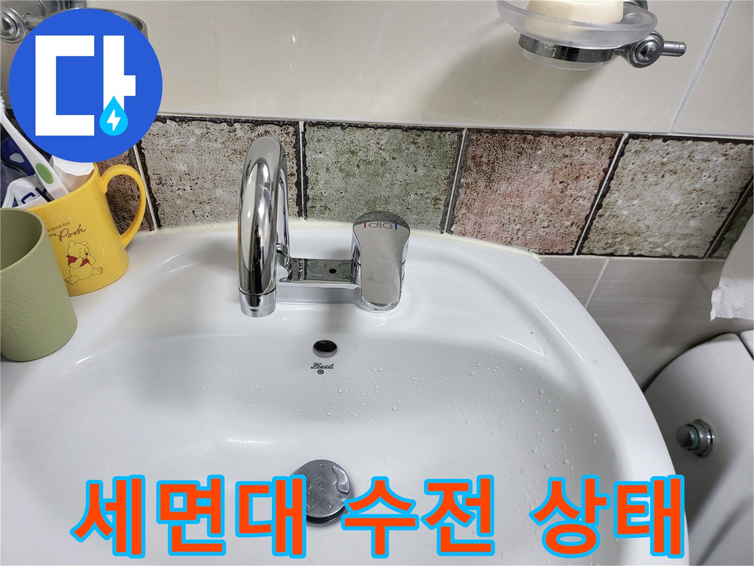 물기가 맺혀있는 세면대 수전과 타일 모습