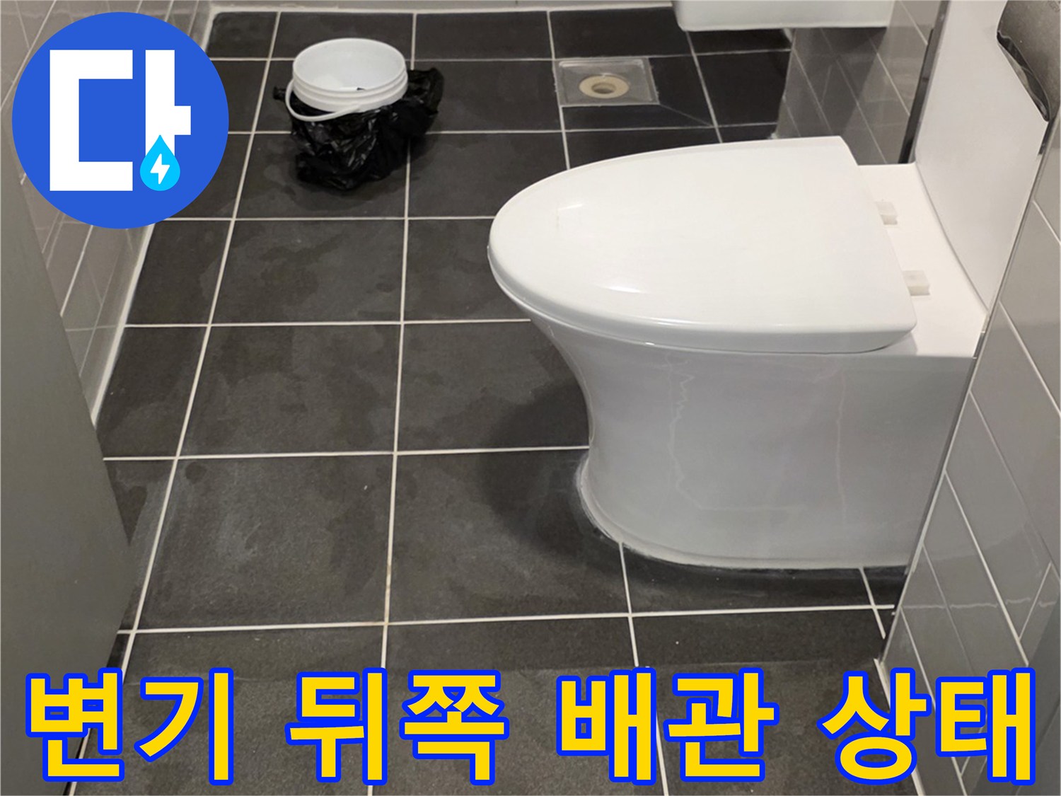 변기 뒷벽의 타일과 배관 연결 부위 사진입니다.
