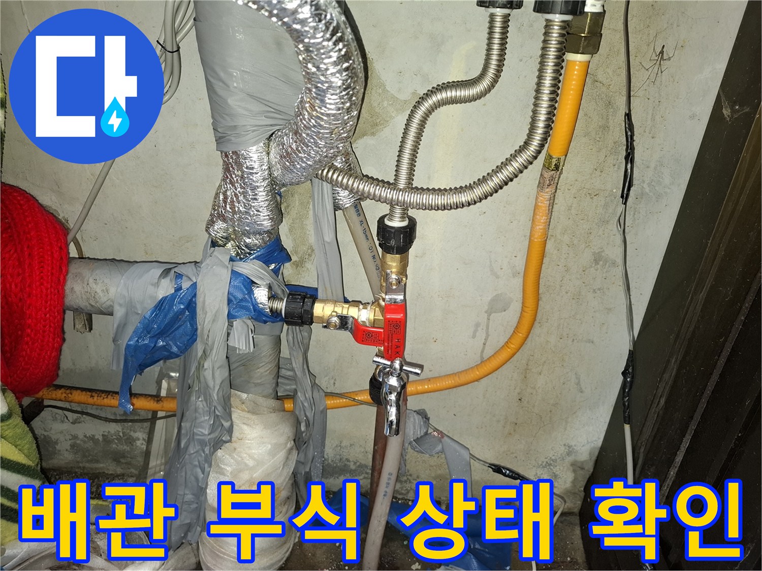 붉은색 밸브와 연결된 금속 배관의 부식 현상