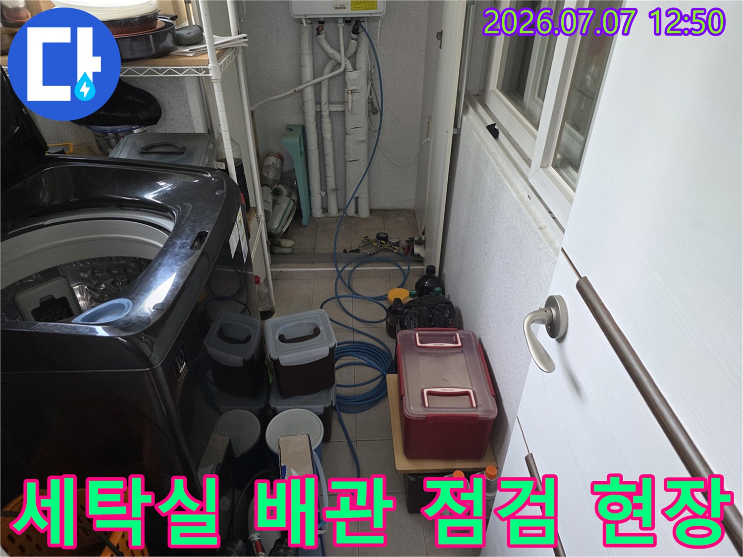 세탁기 옆에 배치된 각종 배관 장비와 수리용 도구들