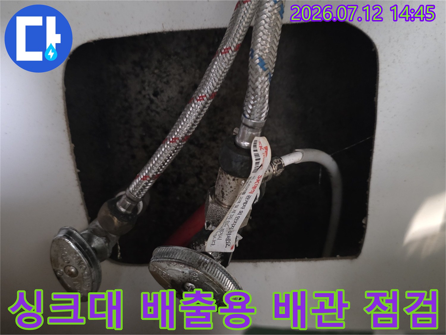 노출된 싱크대 하부 배관과 연결 부위의 상태를 촬영한 사진