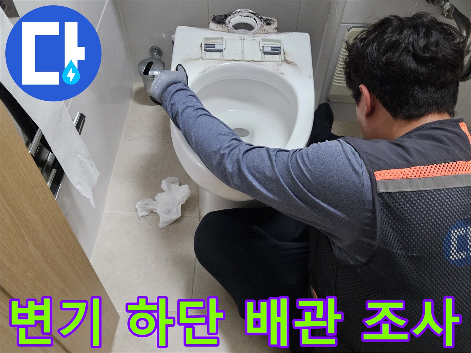 양변기 주변의 배관 연결 상태를 면밀히 관찰하는 작업자