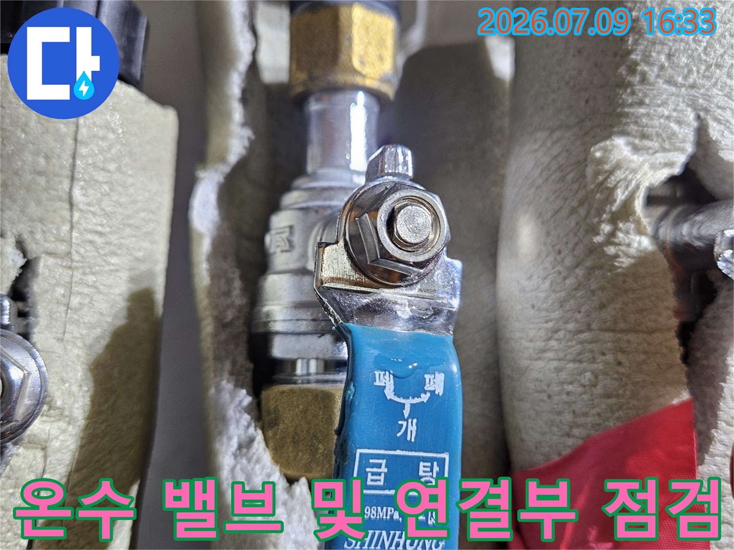 파란색 도색이 된 온수 배관용 멀티 밸브와 금속관의 클로즈업