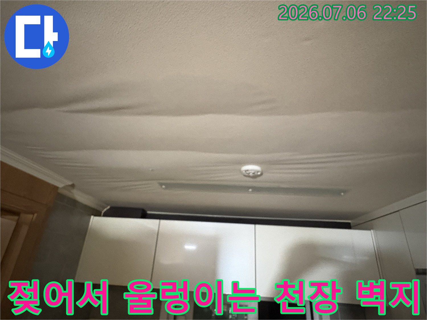 물이 스며들어 물결 모양으로 처진 주방 천장 실크 벽지 모습