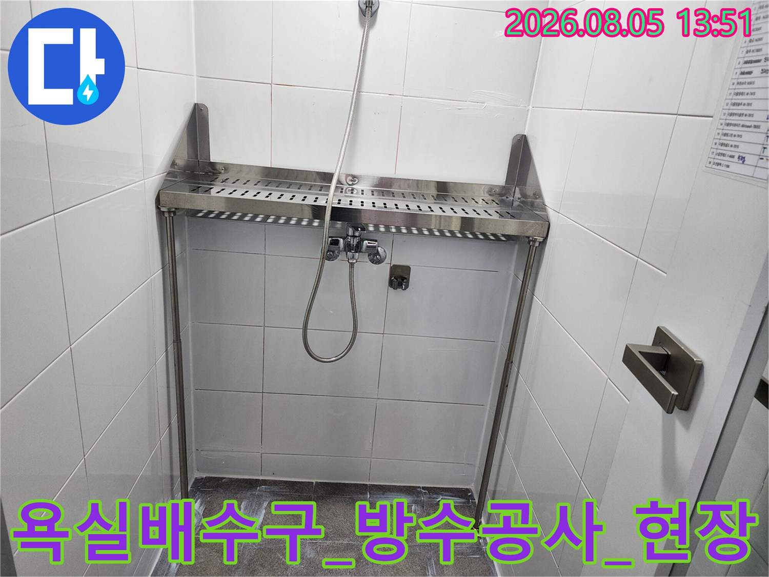 스테인리스 소재의 욕실 배수구와 샤워기 배관이 설치된 현장 모습