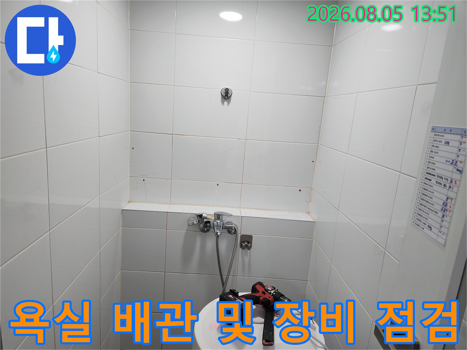 작업용 전동 드릴과 호스가 배치된 욕실 내 배관 점검 현장