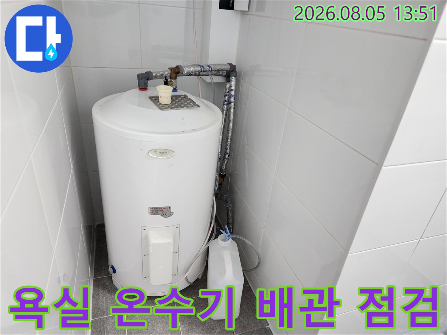 흰색 온수기와 연결된 회색 배관 및 고정 장치 상세 모습