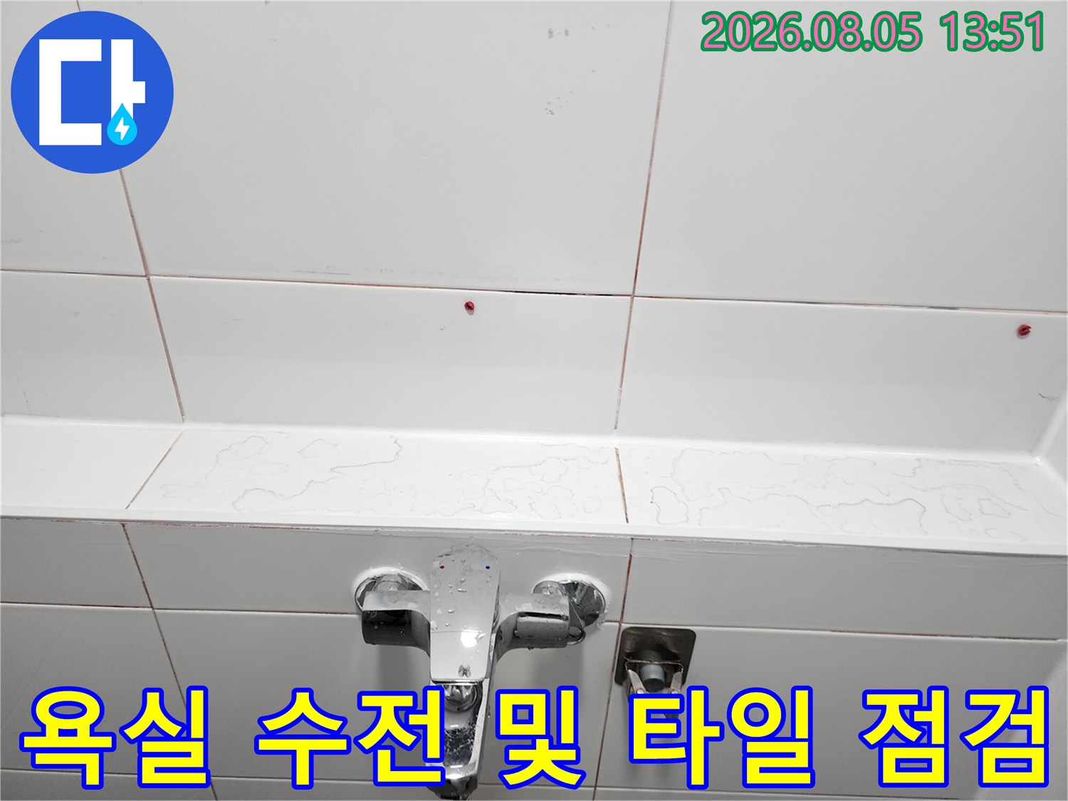 흰색 타일이 시공된 욕실 벽면과 수도꼭지 배관 부위의 상세 모습