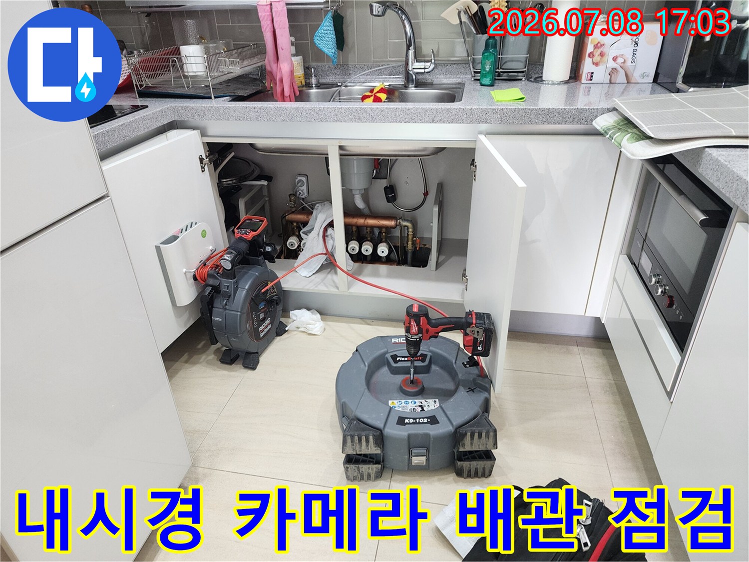 싱크대 아래 공간에서 내시경을 활용하여 복잡한 배관 구조를 정밀하게 진단하는 모습