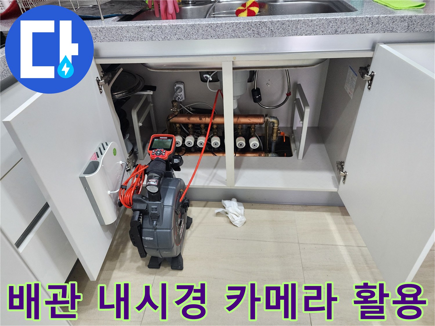 싱크대 하부장 내부의 복잡한 배관과 점검용 내시경 장비