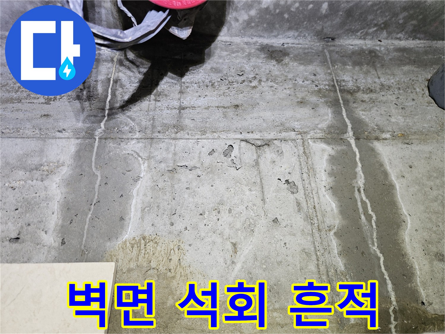 누수로 인해 형성된 벽면의 하얀색 석회 자국과 젖은 부위