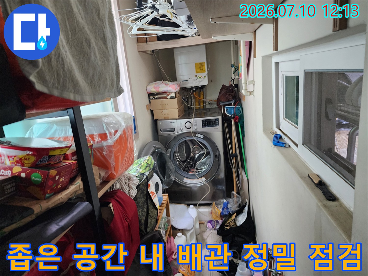 세제와 세탁기가 비치된 좁은 구역의 노출 배관 점검 사진