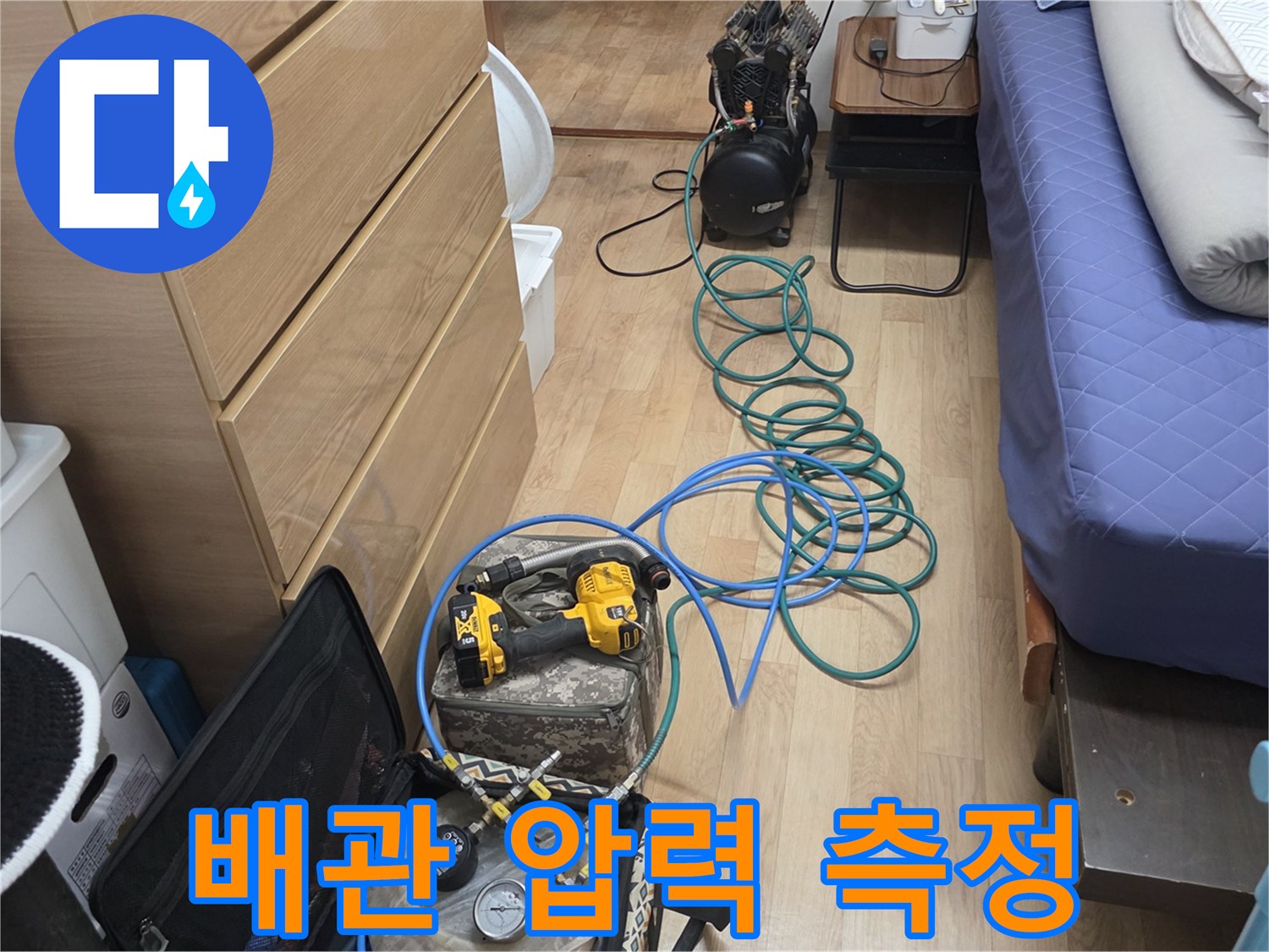 파란색 호스와 디지털 게이지로 구성된 배관 검사 장비입니다.