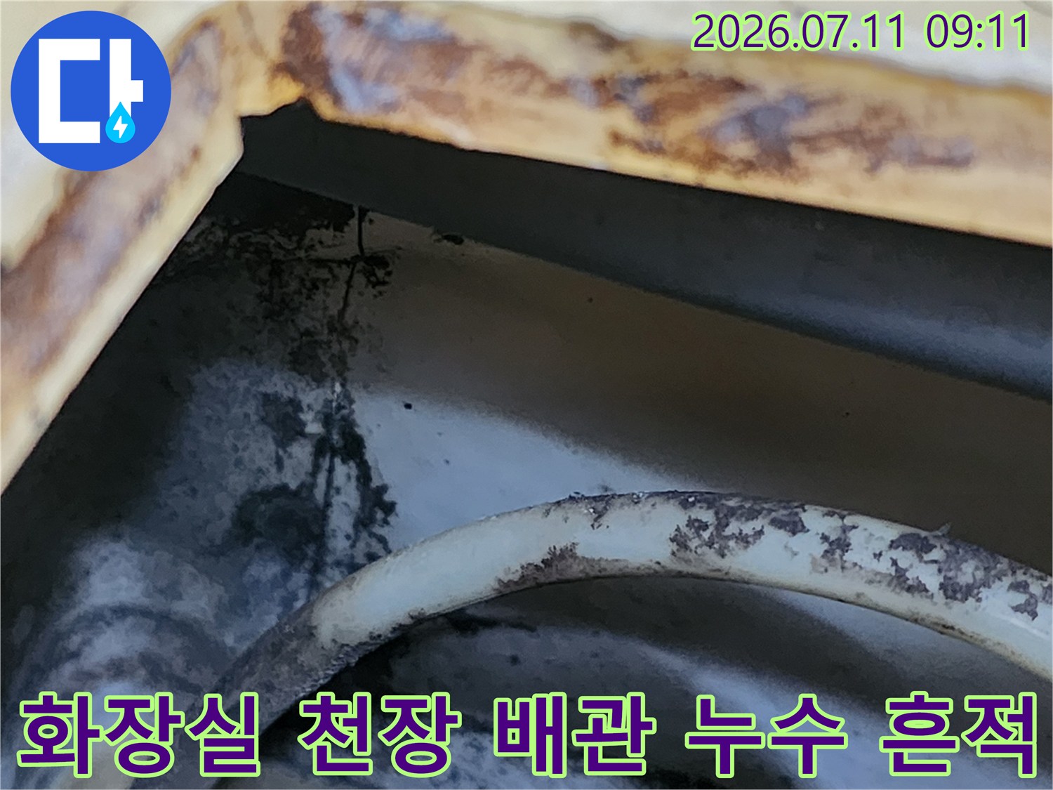 화장실 천장 내부의 젖은 배관과 얼룩진 벽면 모습