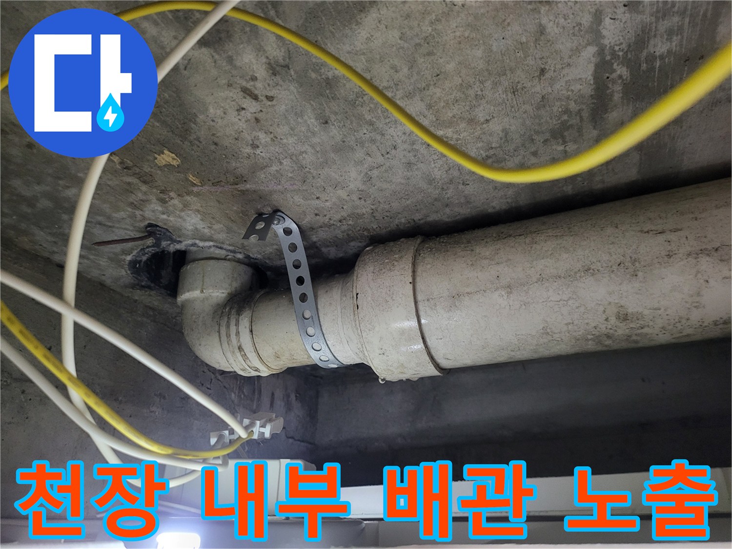 천장 콘크리트 구조물 아래로 지나가는 하수관의 모습입니다.