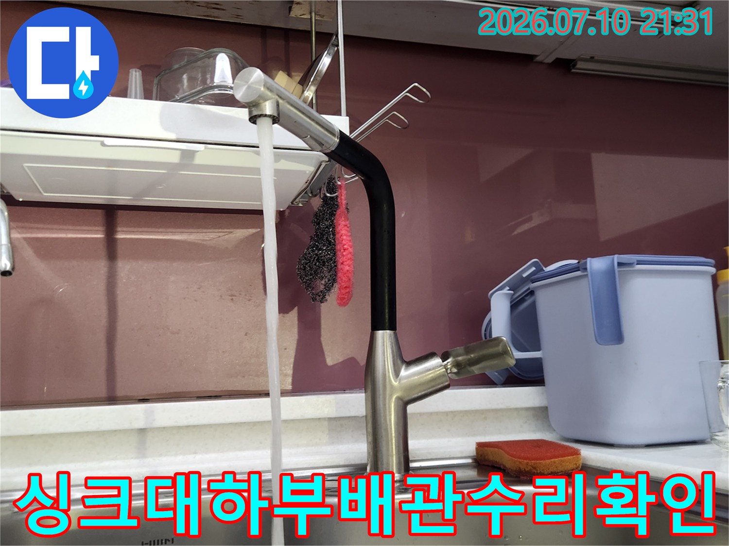 싱크대 하부 공간에서 온수 배관 연결 부위와 앵글밸브를 점검하는 모습