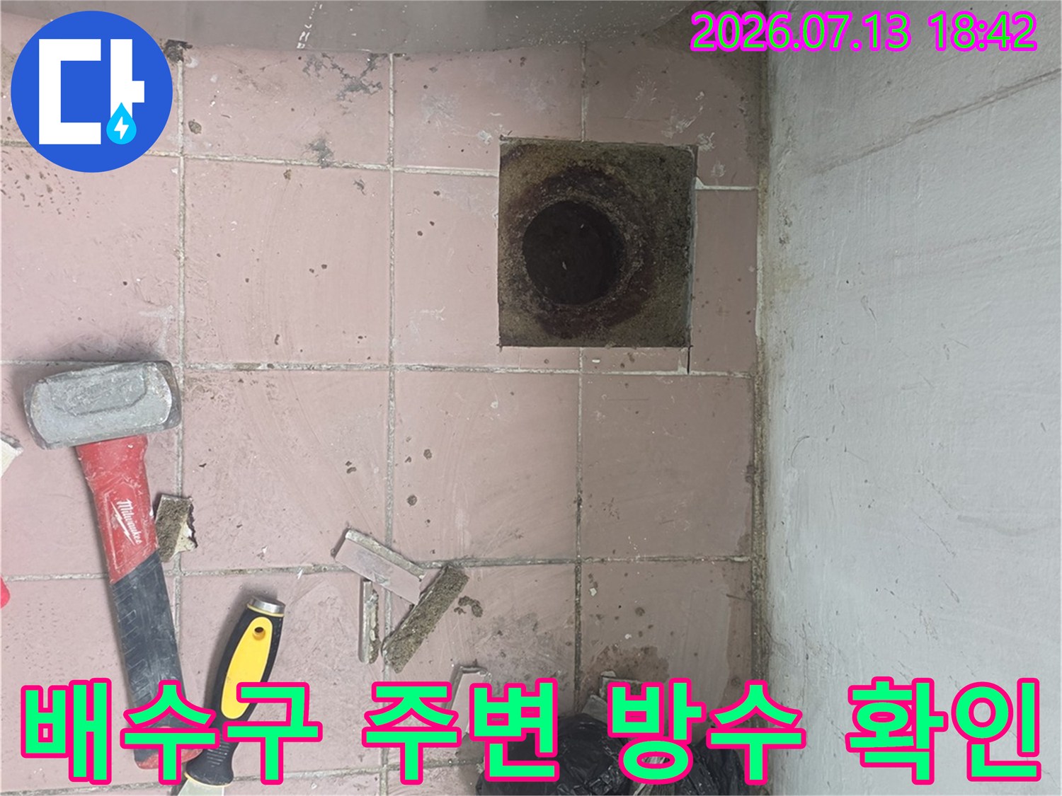 손상된 배수구 주변 타일과 노출된 하수관 점검