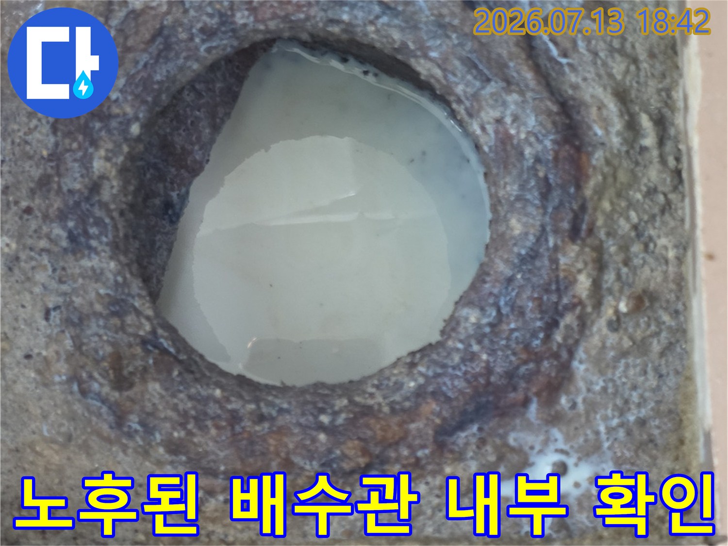 오염된 배수구 주변을 제거하고 노출된 내부 배관 구조를 점검하는 모습