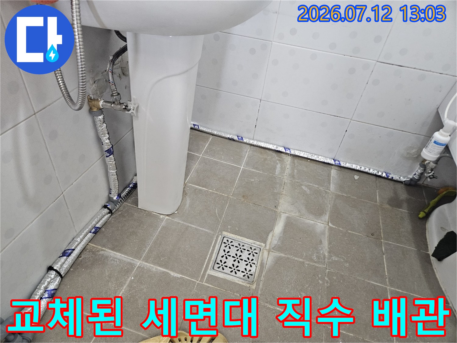 세면대 주변 노출형으로 시공된 직수 배관과 보호재 마감 처리