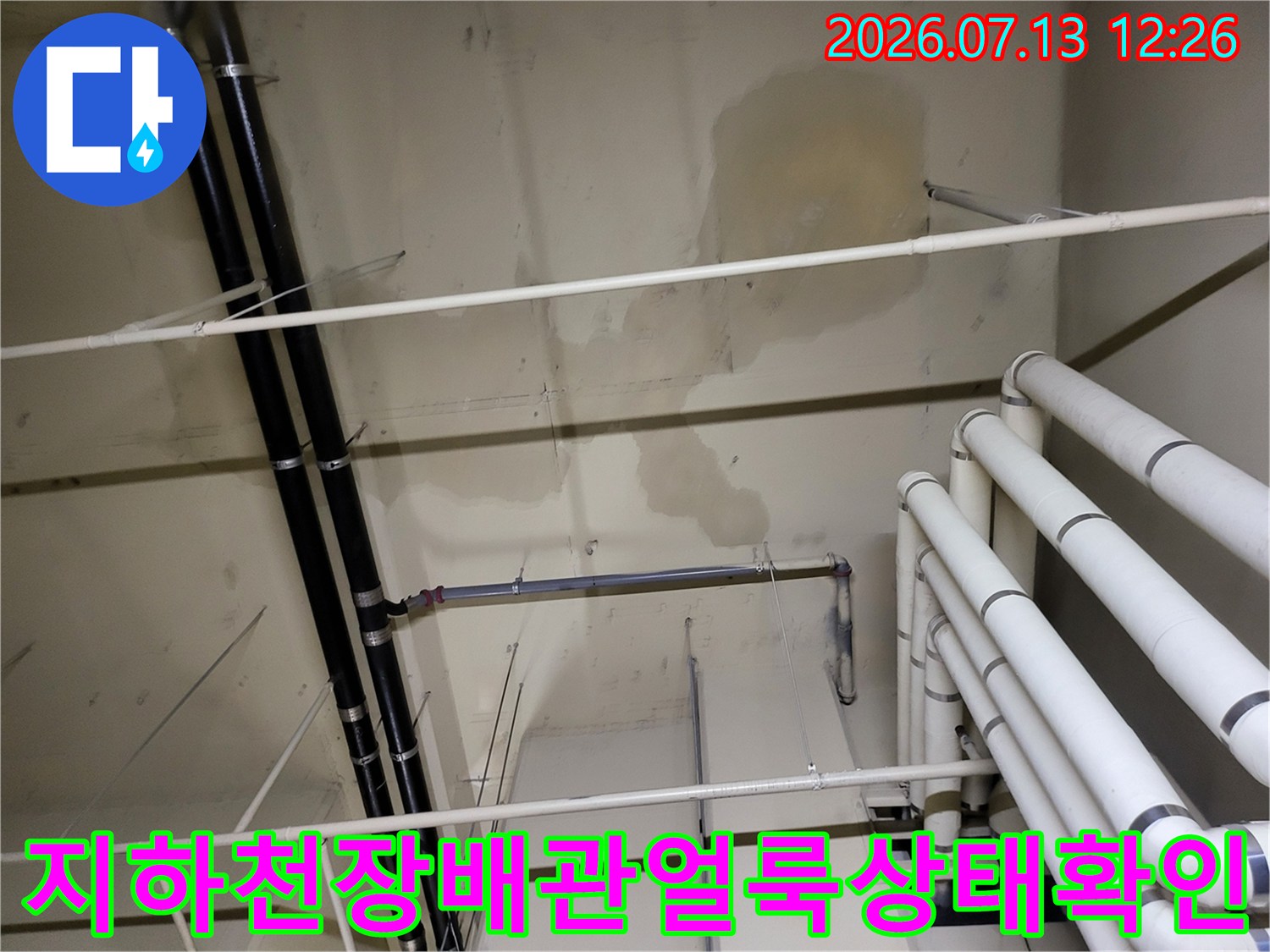 복잡하게 얽힌 배관과 누수 얼룩이 남은 지하 천장 점검 장면