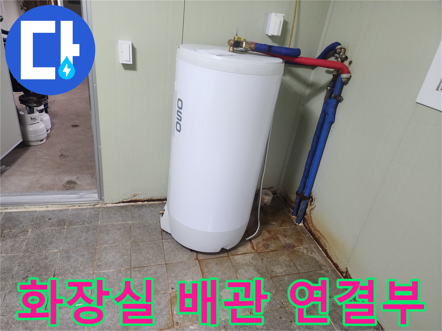 온수기 하단에 연결된 파란색과 빨간색 배관의 모습