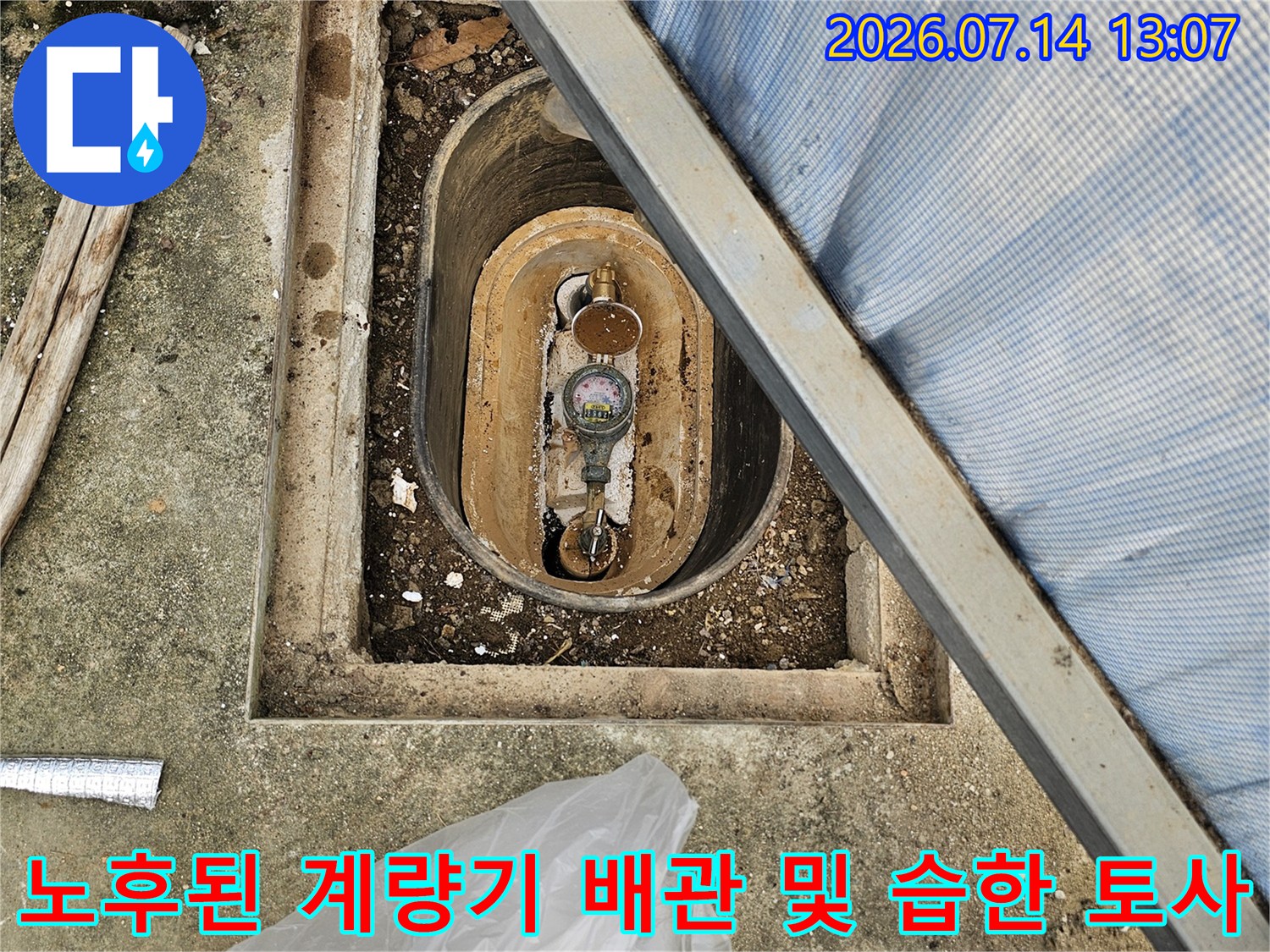 계량기 함 안쪽의 젖은 토사와 노출된 수도 배관