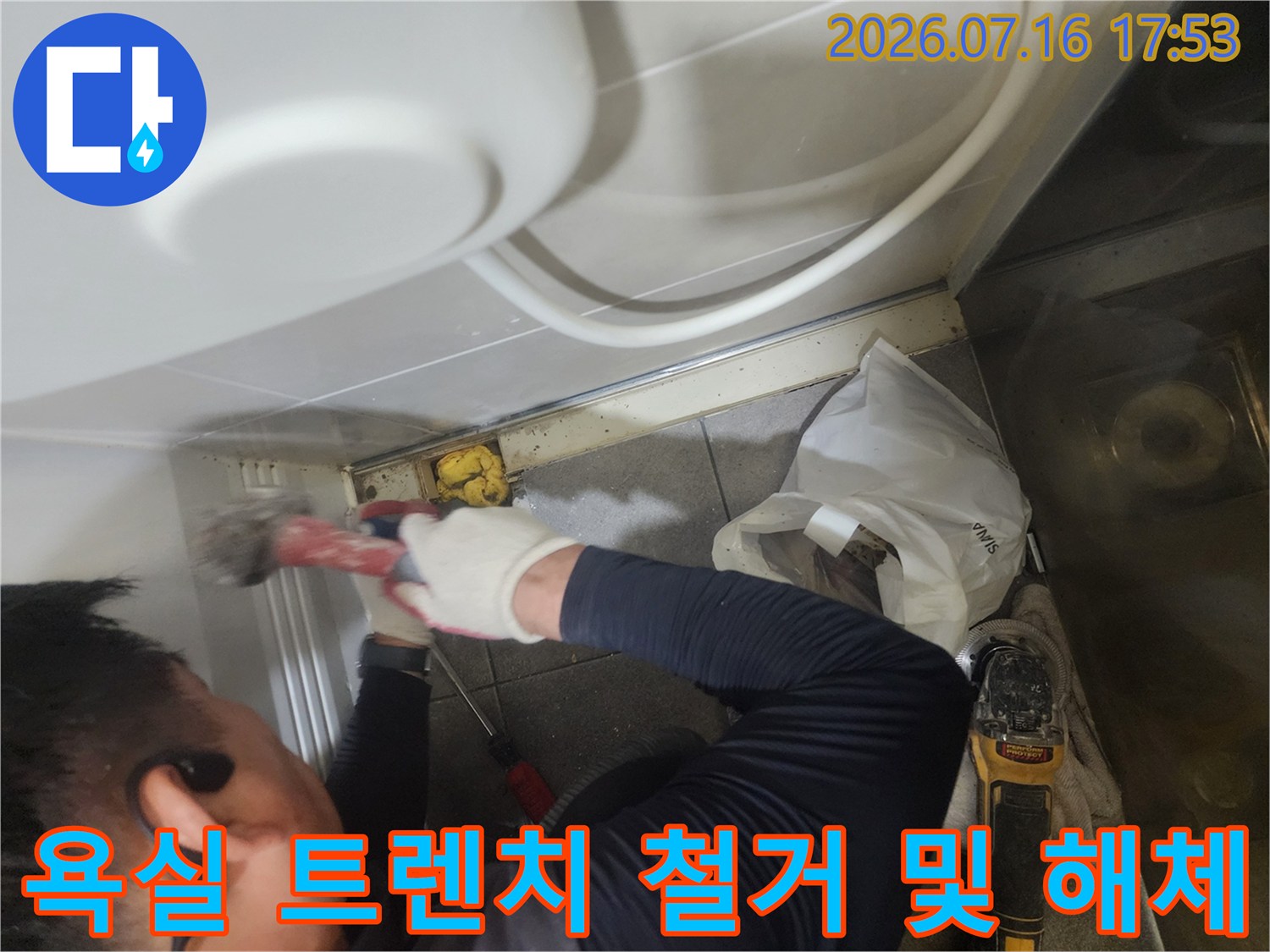 장비를 사용하여 욕실 바닥 배수구 부위의 유가를 제거하는 작업 장면