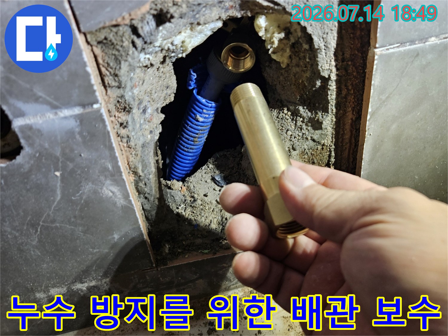 파란색 유연 호스와 새 소모품을 대조하며 욕조 하단 누수 지점을 점검하는 모습