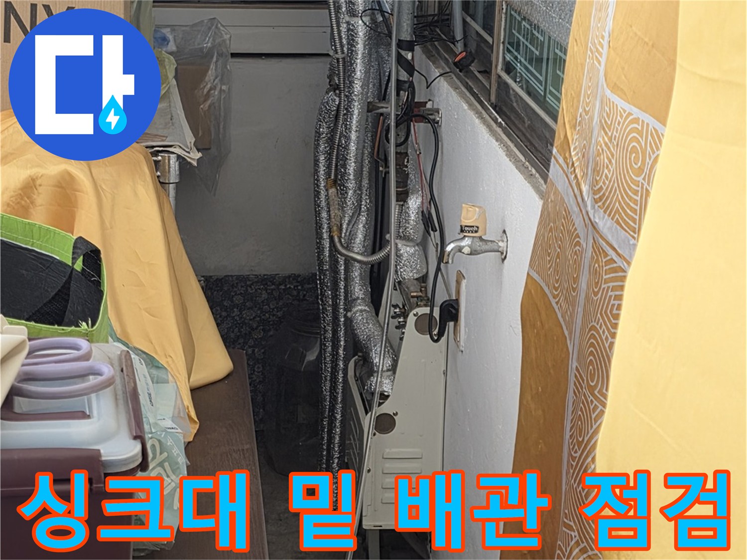 보온재로 덮인 수도 배관의 연결 부위를 정밀하게 살피는 현장 사진입니다.