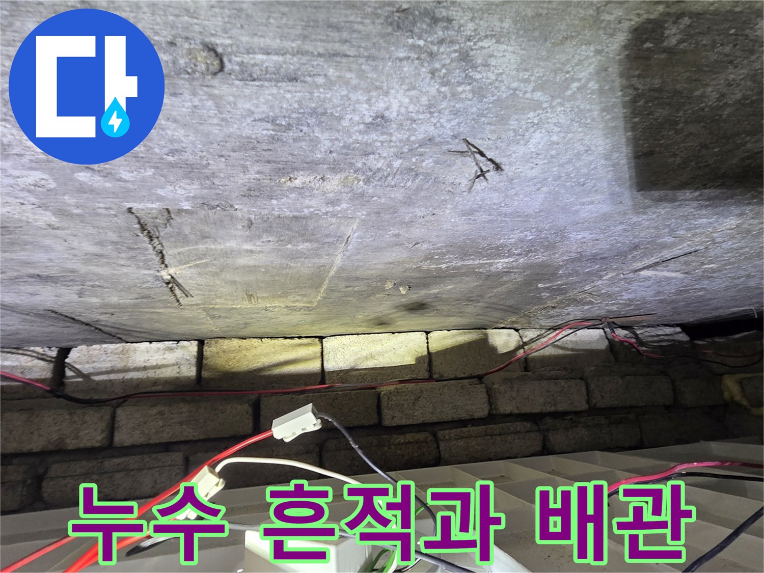 축축하게 젖은 천장 슬래브와 노출된 배관 연결부