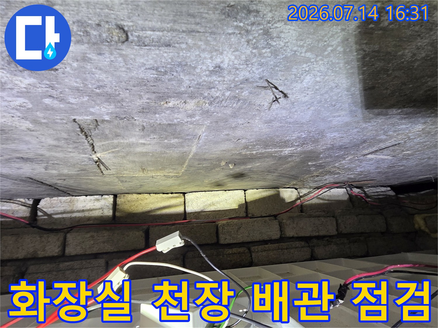 화장실 천장 내부에 설치된 노출 배관과 압력 테스트 장비 연결 상태
