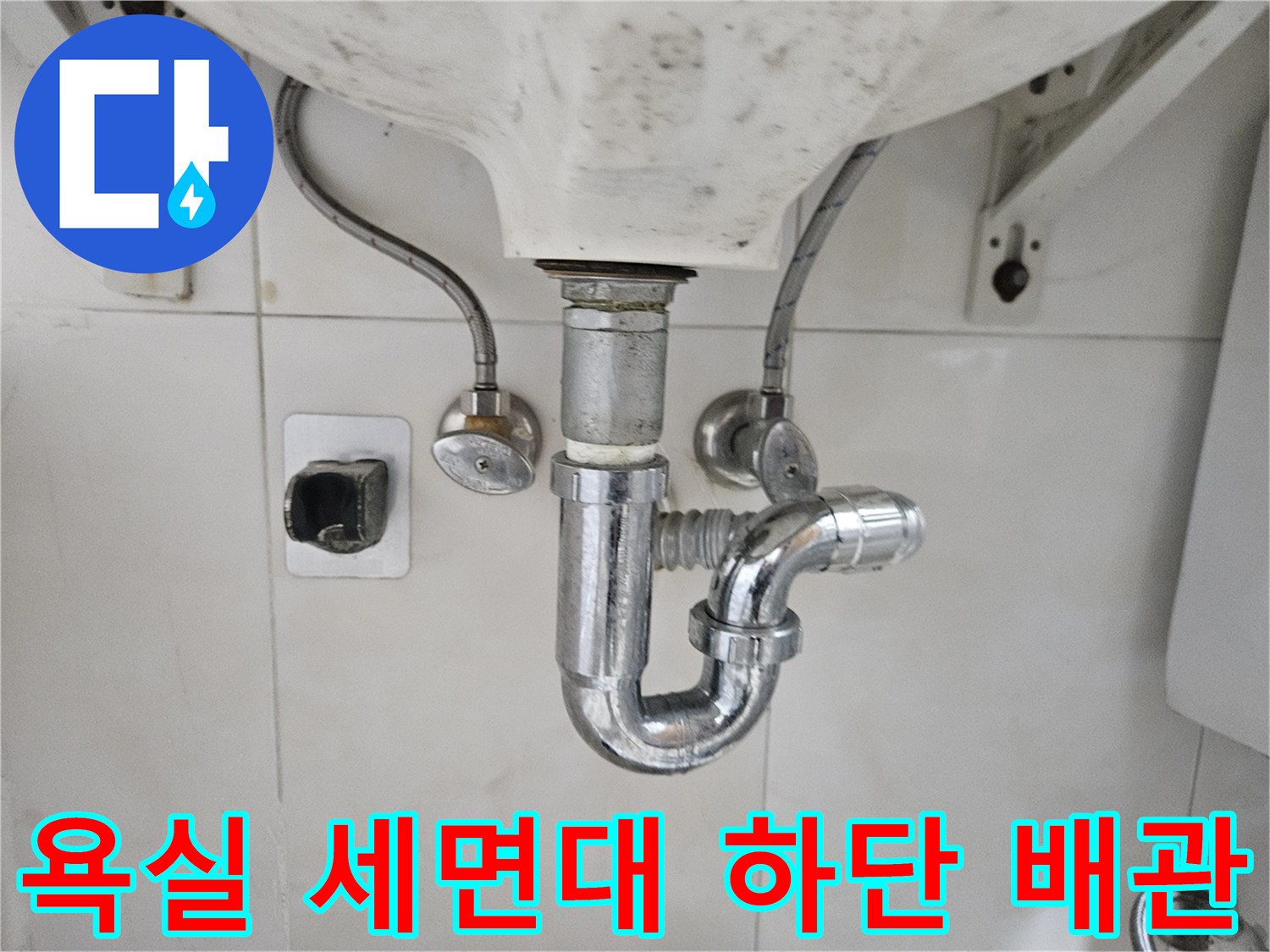 세면대 아래 설치된 금속 재질의 급수 및 배수 배관