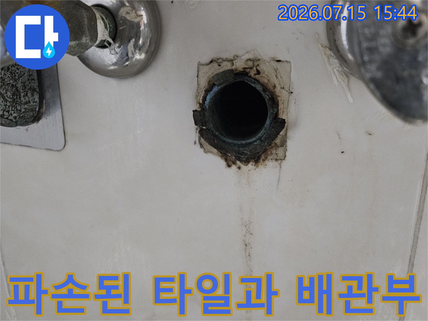 세면대 하단에 위치한 노후 배관의 단면과 주변 마감재 손상 상태