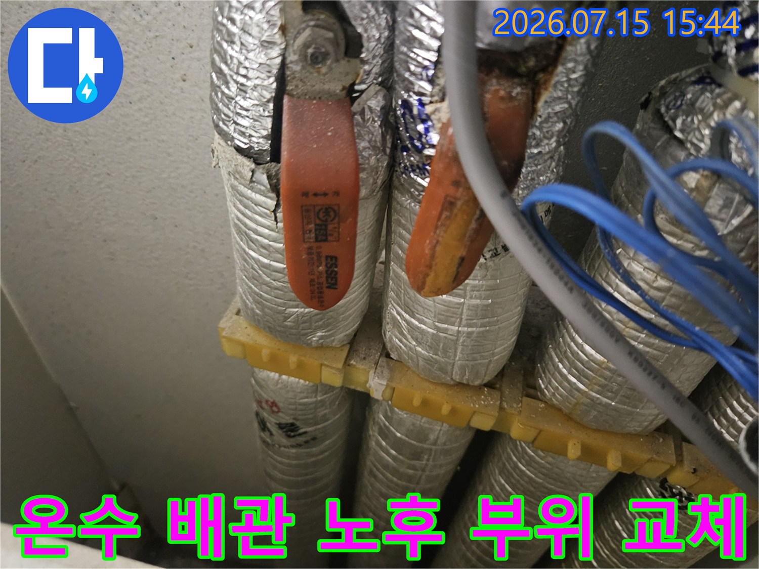 은박 단열재 보호망 사이로 설치된 노란색 배관 연결부의 클로즈업 사진