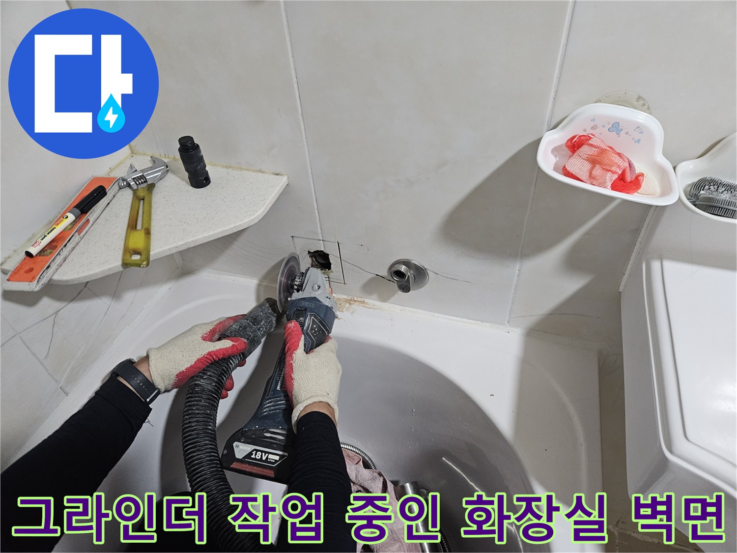 타일 절단기를 사용하여 벽면 타일을 제거하는 공사 모습