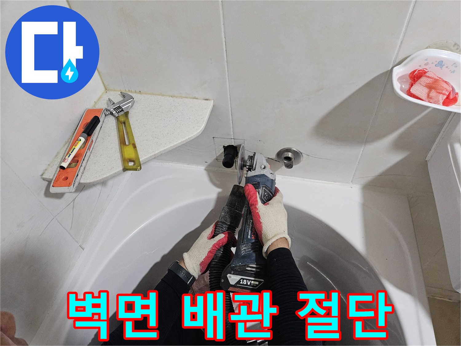 화장실 벽체 내부에 위치한 수도 배관을 자르는 공사 장면