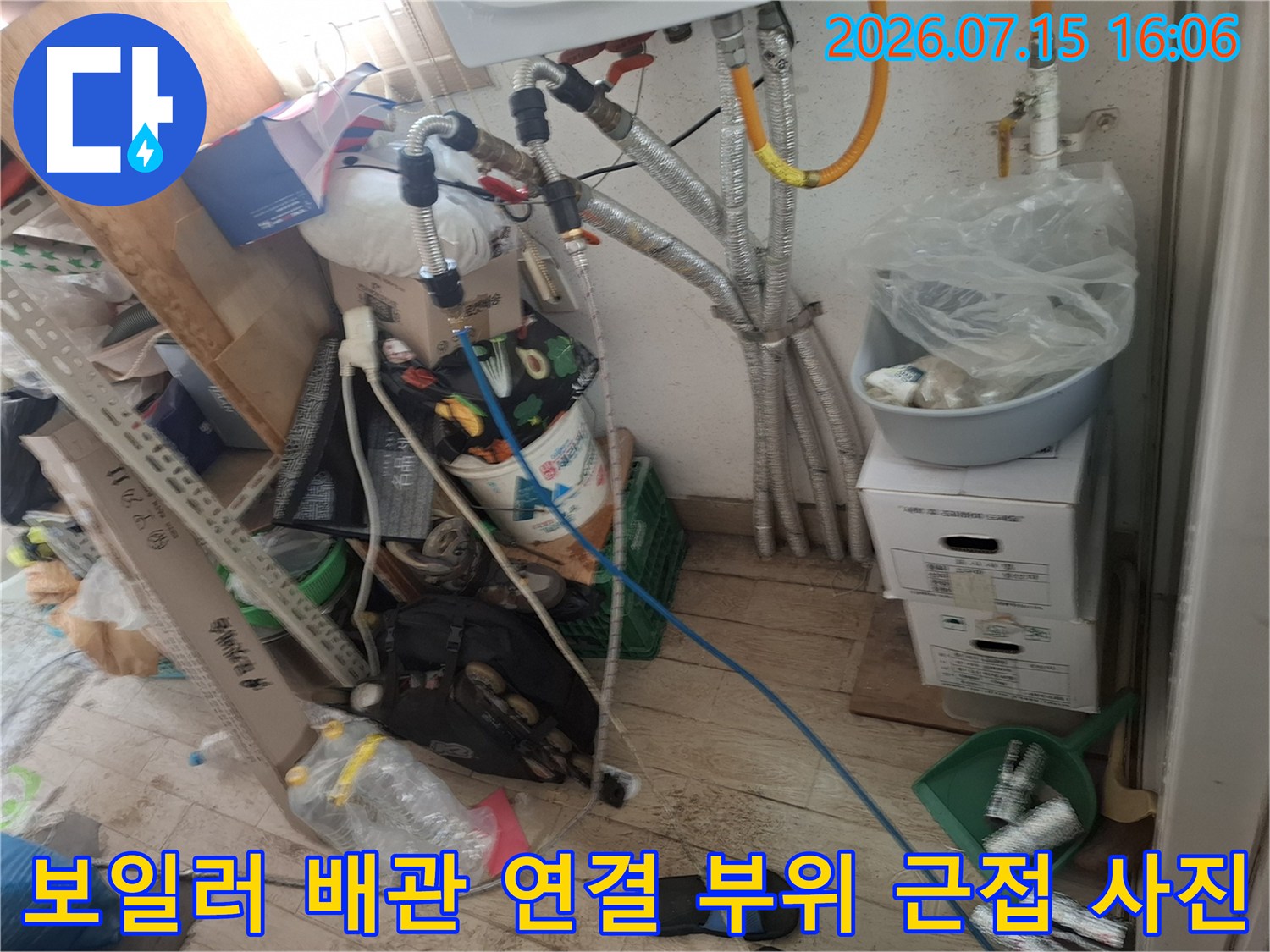 보온재로 감싸인 금속 배관과 그 사이로 지나가는 파란색 호스의 복잡한 구성-누수 점검